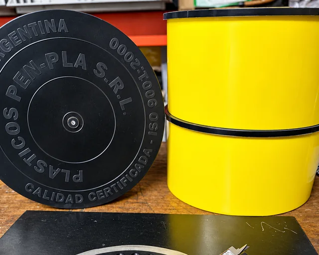 Placa de sembradora medida con calibre junto a discos y cilindros plásticos Pen-Pla